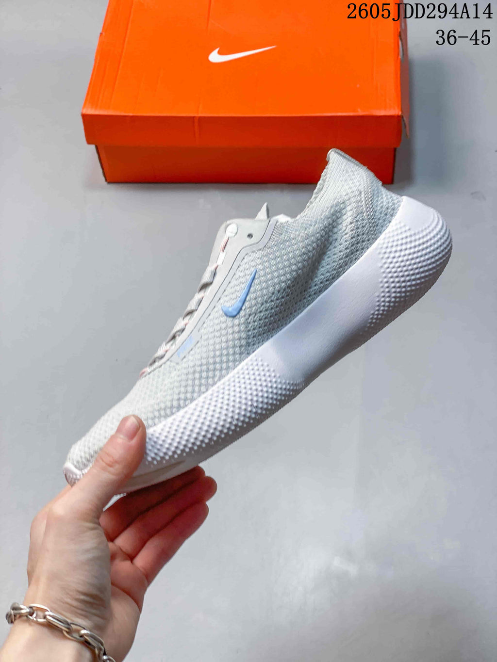 Side profile of a light gray Nike Free shoe with blue accent and textured white sole