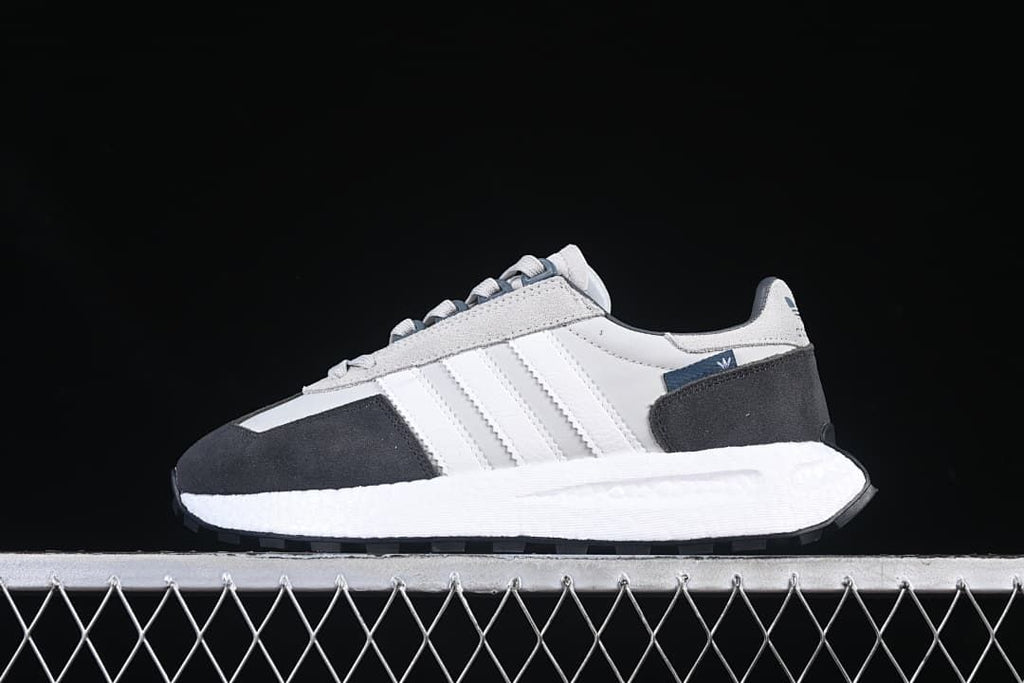 Side profile of a single gray, white, and charcoal sneaker