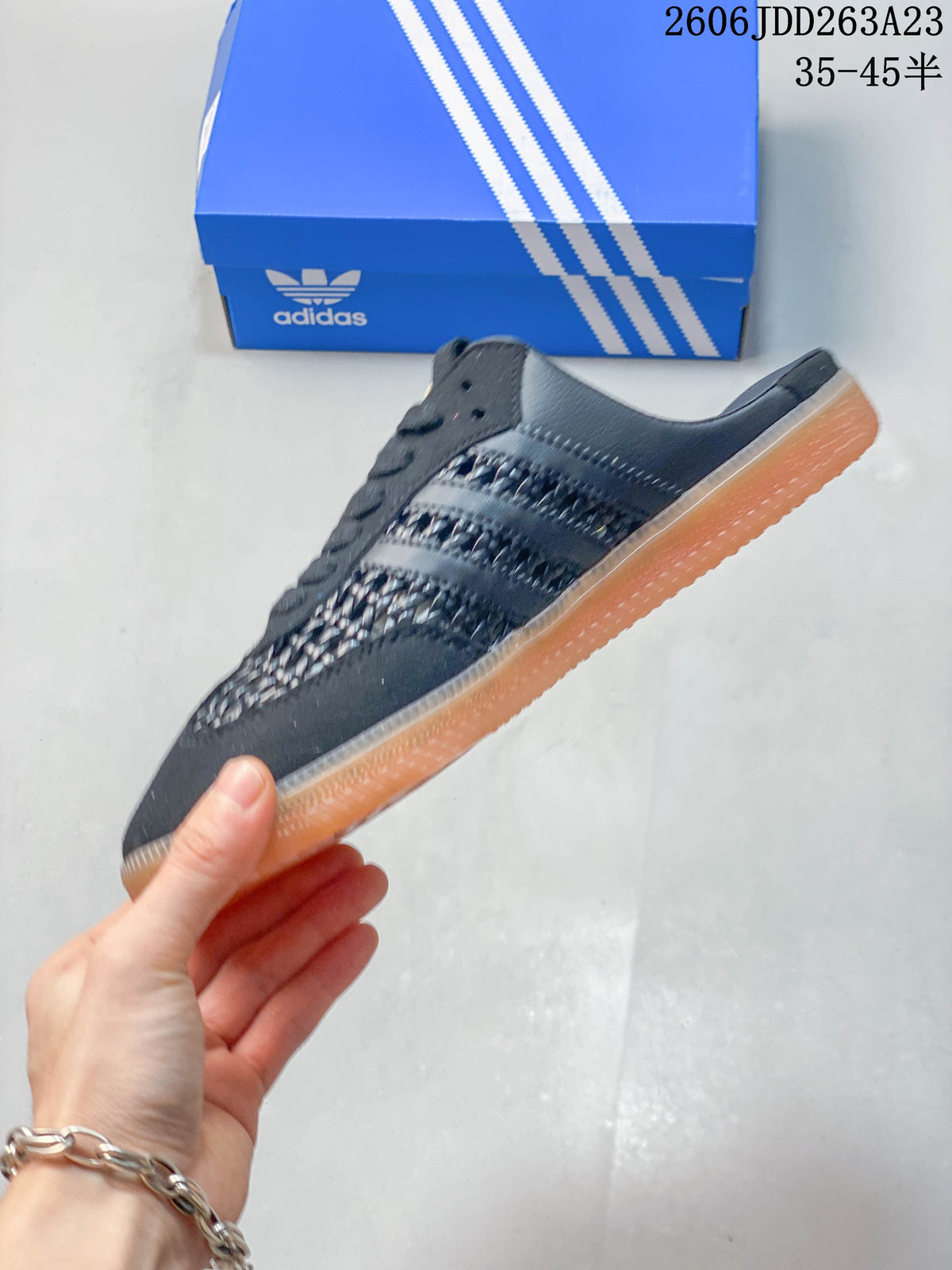 Side view of a dark gray Samba OG Mule with three stripes and woven-look panels