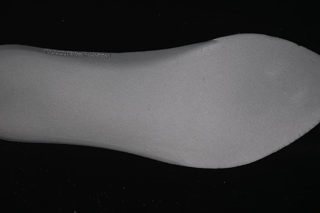 Close-up of the light-colored shoe insert with a printed code.