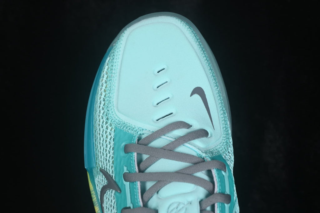 Close-up of the shoe toe box with ventilation slits, gray laces, and a dark Nike Swoosh.