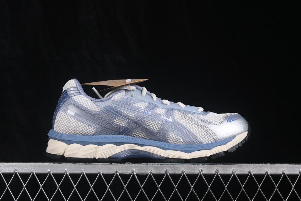 Side profile of the sneaker showing the mesh upper, translucent overlays, blue midsole detailing, and cream outsole.