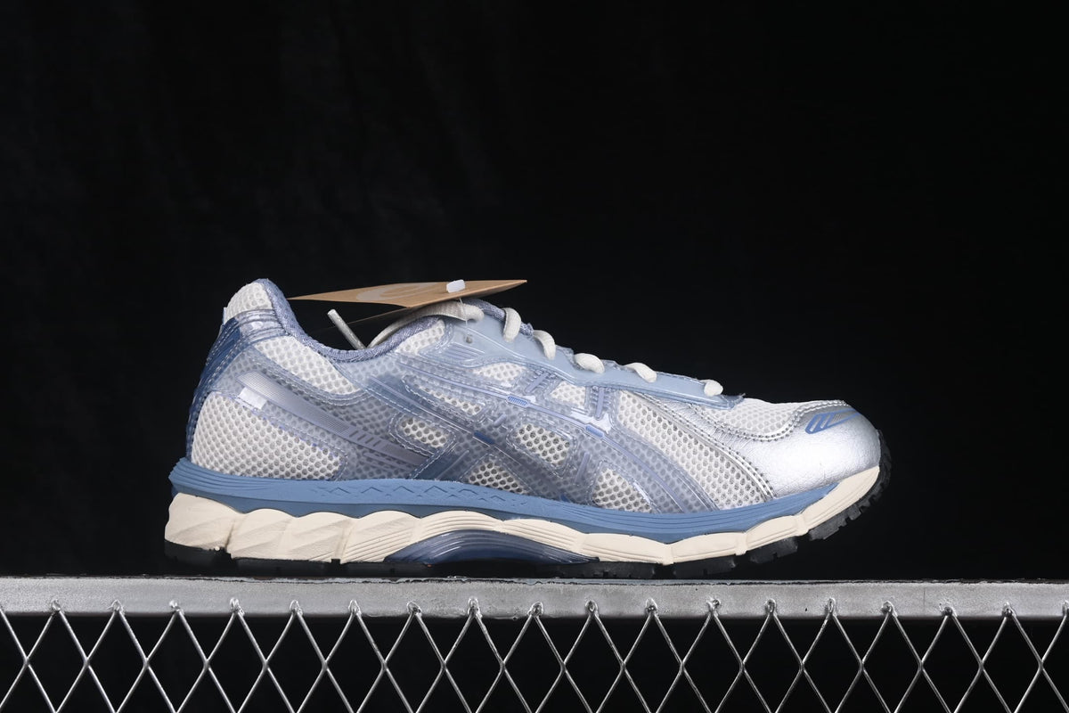 Side profile of the sneaker showing the mesh upper, translucent overlays, blue midsole detailing, and cream outsole.