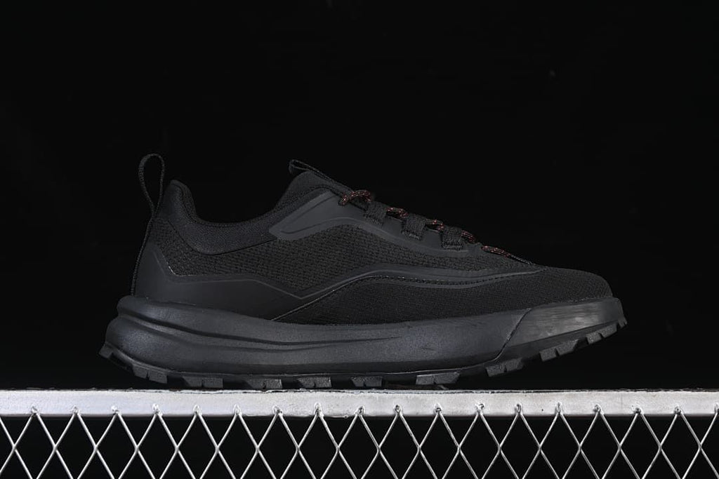Side profile of the black low-top shoe with red-accented laces