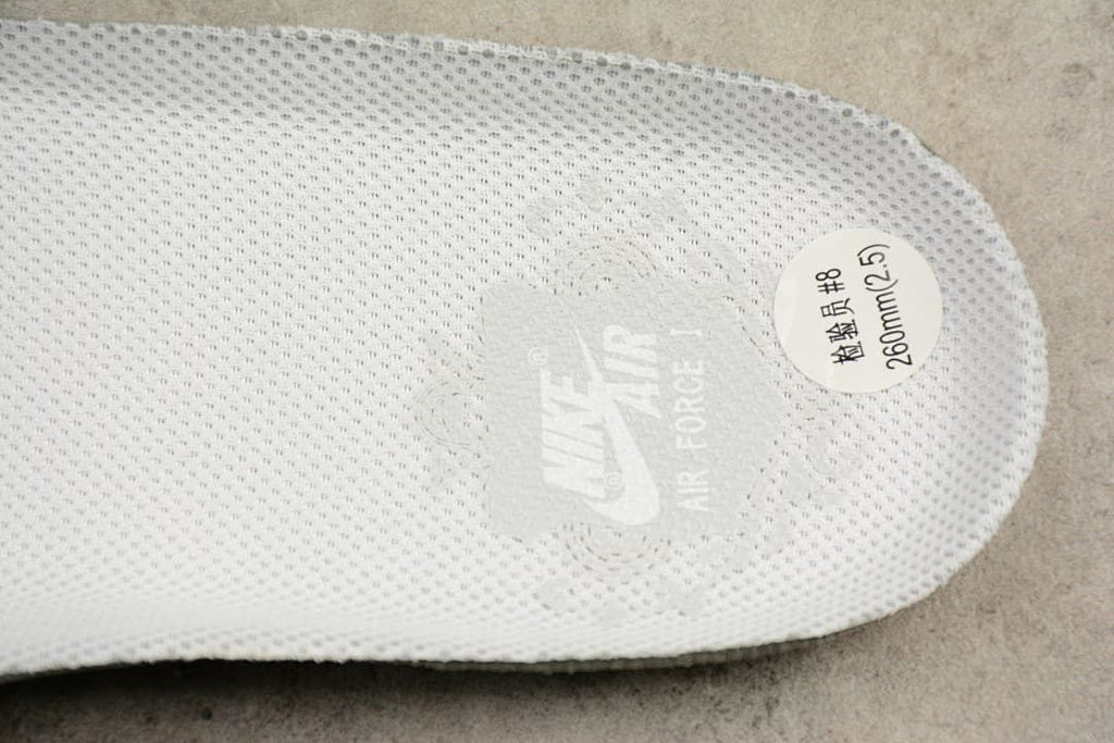 White insole with branding and a round size sticker marked 260 mm.