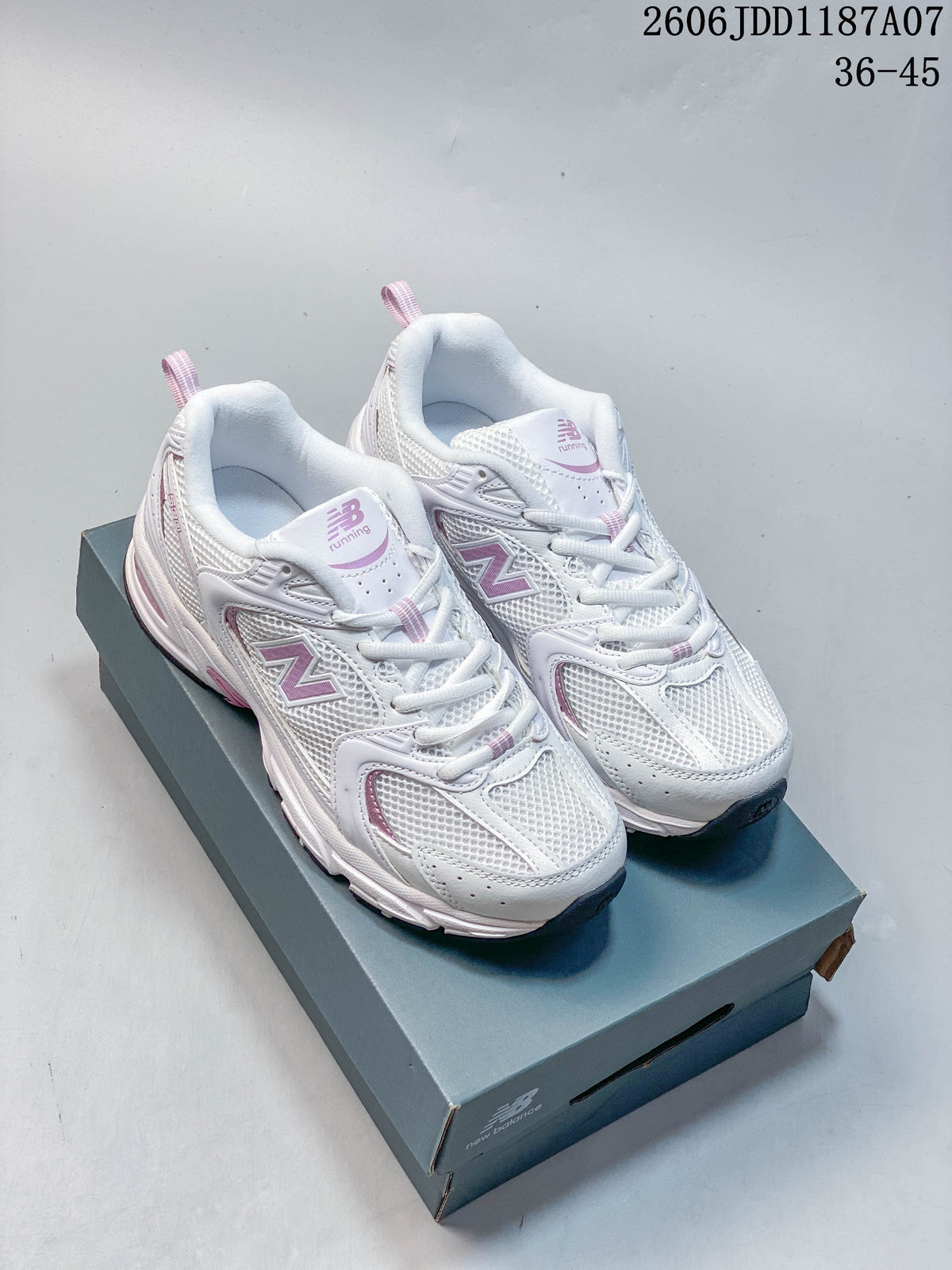 Pair of white and pink New Balance 530 sneakers shown from above on a shoe box