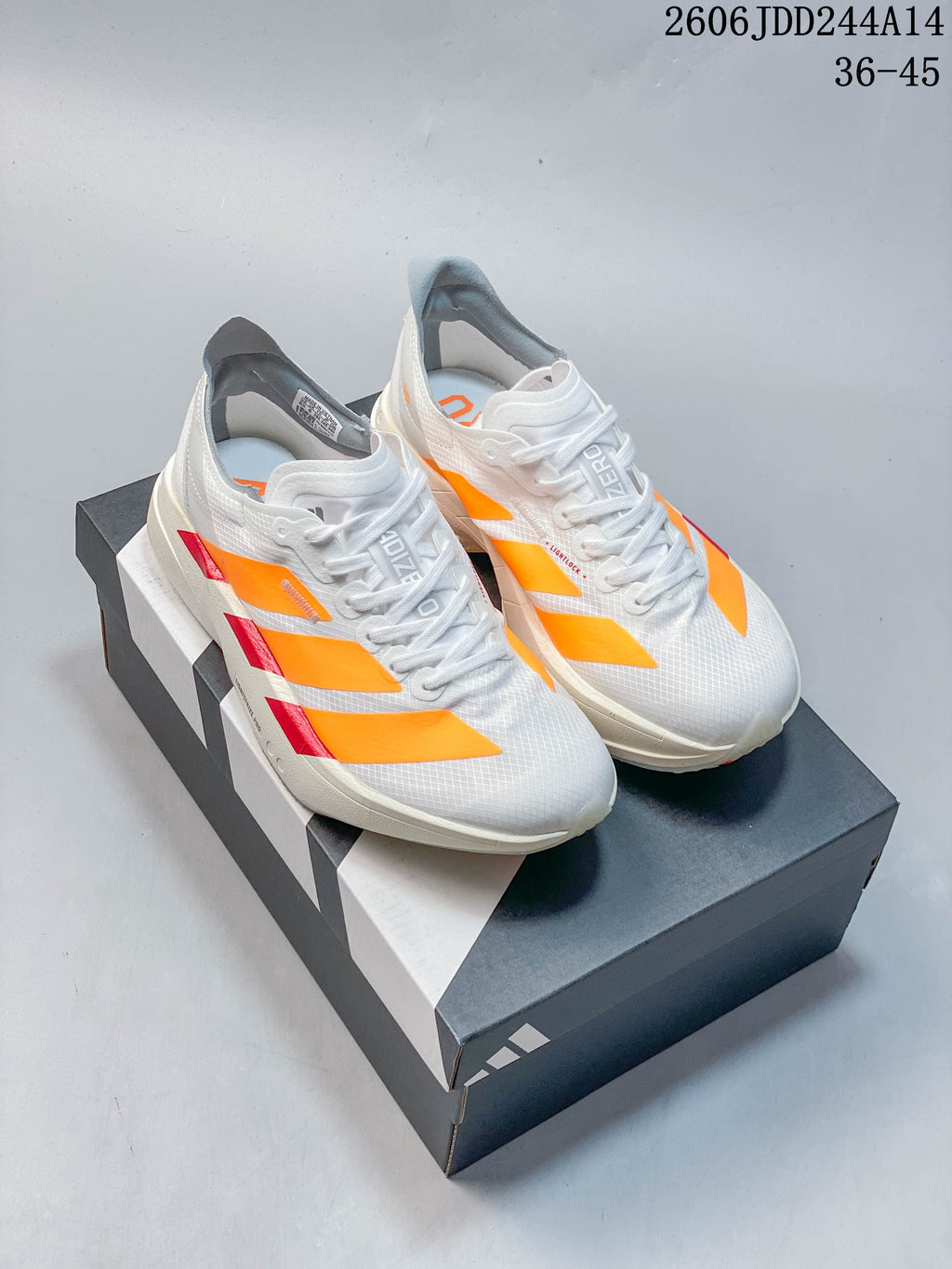 Pair of white Adidas Adizero Adios Pro 4 running shoes with orange stripes and red accents, displayed on a shoebox; image overlay states EU sizes 36–45.