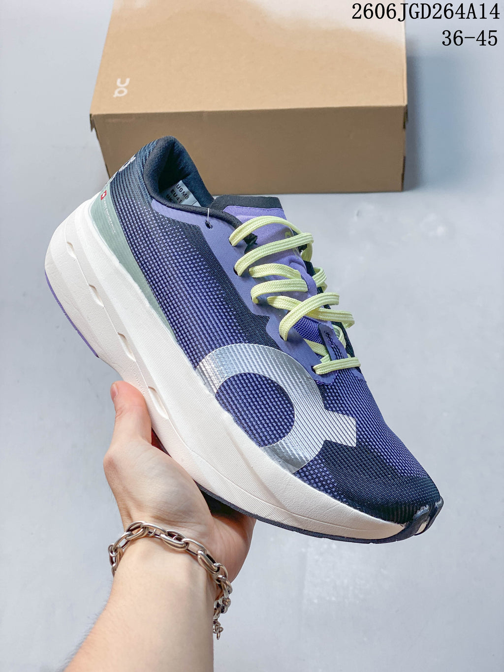 Side view of a navy and purple On Cloudboom Volt running shoe with lime laces.