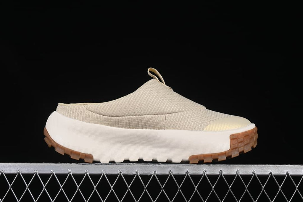 Side profile of the mule sneaker showing its closed toe, open heel, and tread.