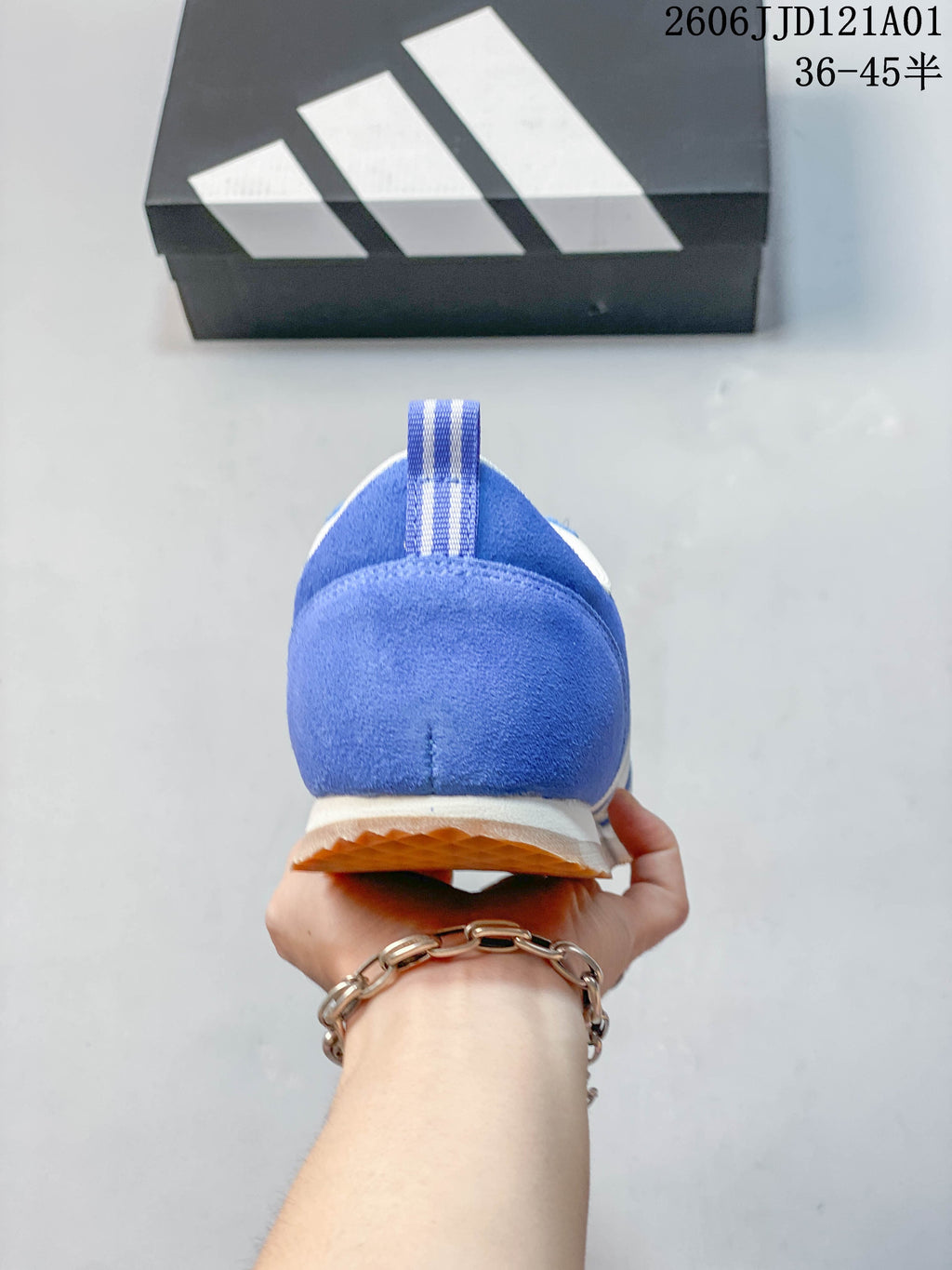 Rear view of the blue sneaker showing its striped heel pull tab