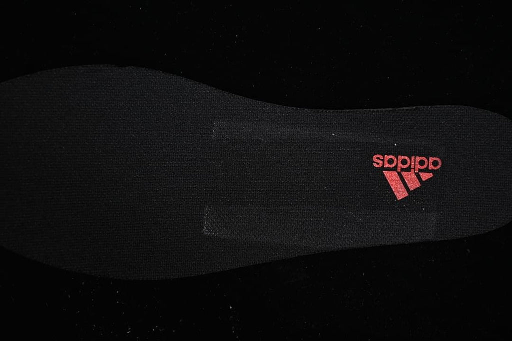 Black insole with a red Adidas logo.