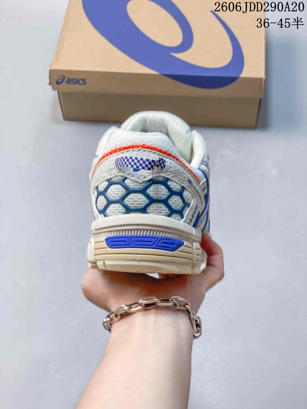 Rear view of the sneaker showing blue heel details and orange trim.