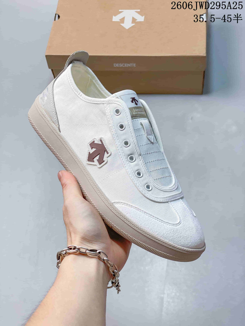 Side view of a white DESCENTE CHRON sneaker with a textured outsole