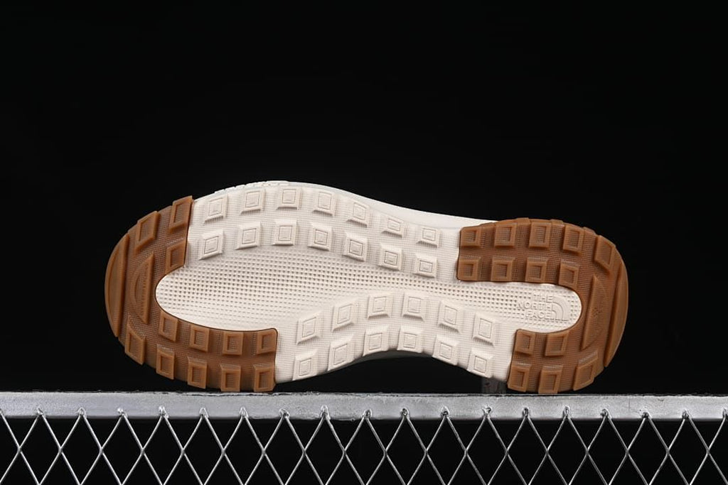 Underside of the shoe showing a block-pattern tread outsole.
