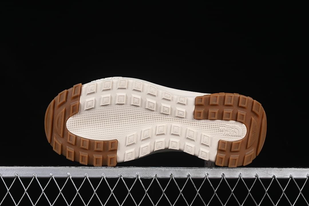 Underside of the shoe showing a block-pattern tread outsole.