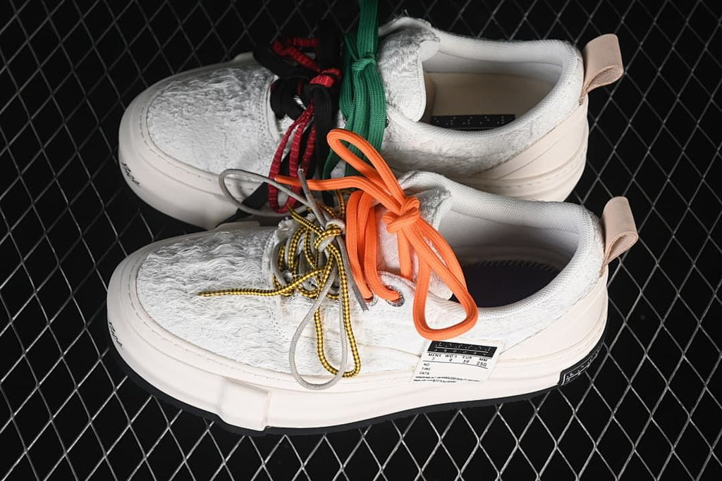 Pair of white platform sneakers arranged with colorful laces.