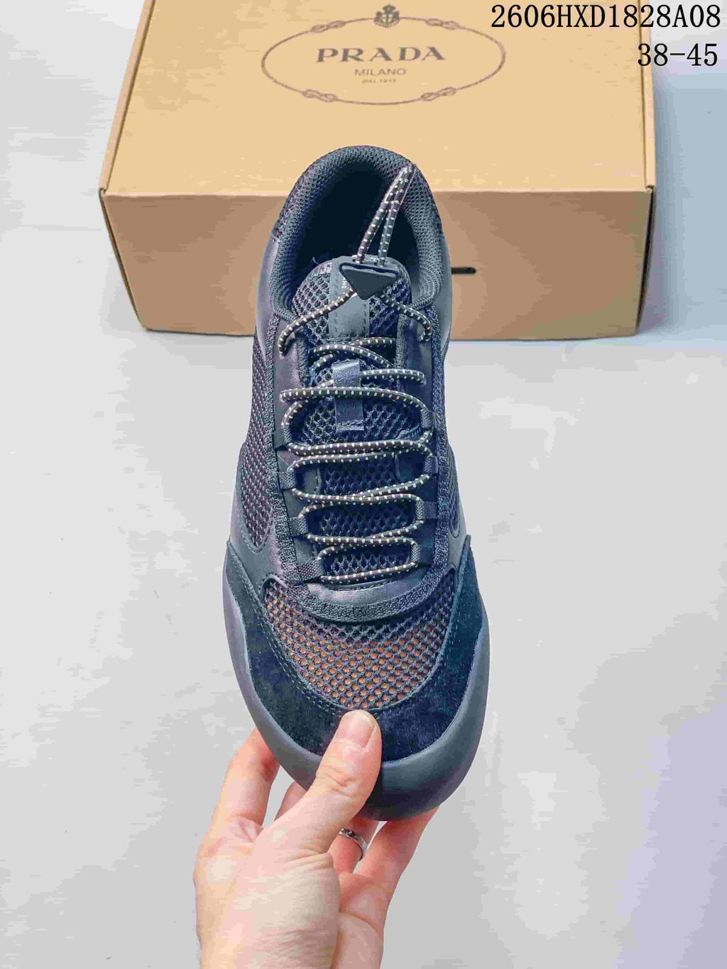 Top view of a dark blue mesh sneaker showing its patterned laces and triangular lace detail.