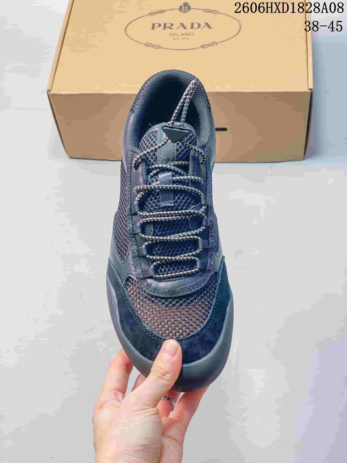 Top view of a dark blue mesh sneaker showing its patterned laces and triangular lace detail.