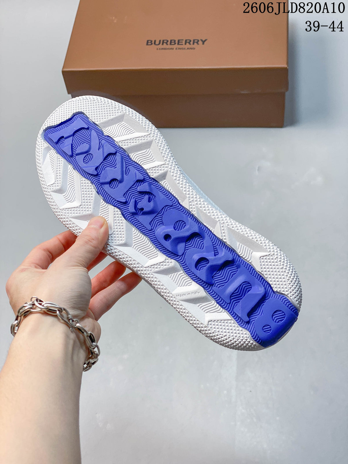 Underside of a white sneaker showing a textured sole and blue center detail