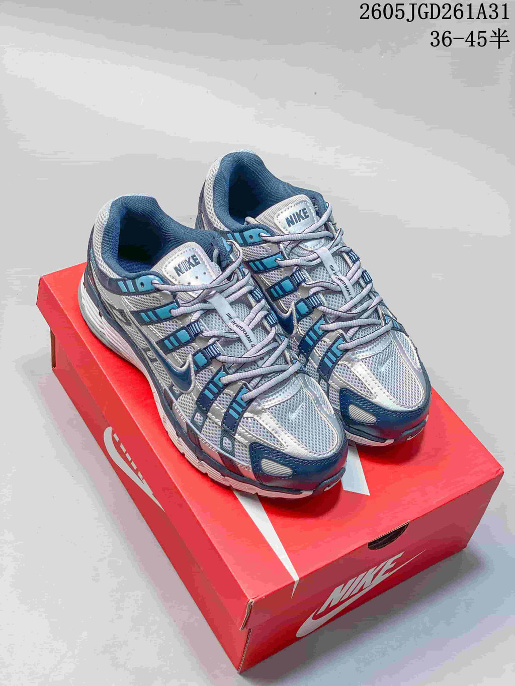 Pair of gray and white Nike P-6000 sneakers with blue accents.
