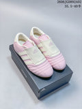 Pink and off-white Adidas Taekwondo shoes shown from the front on a shoebox