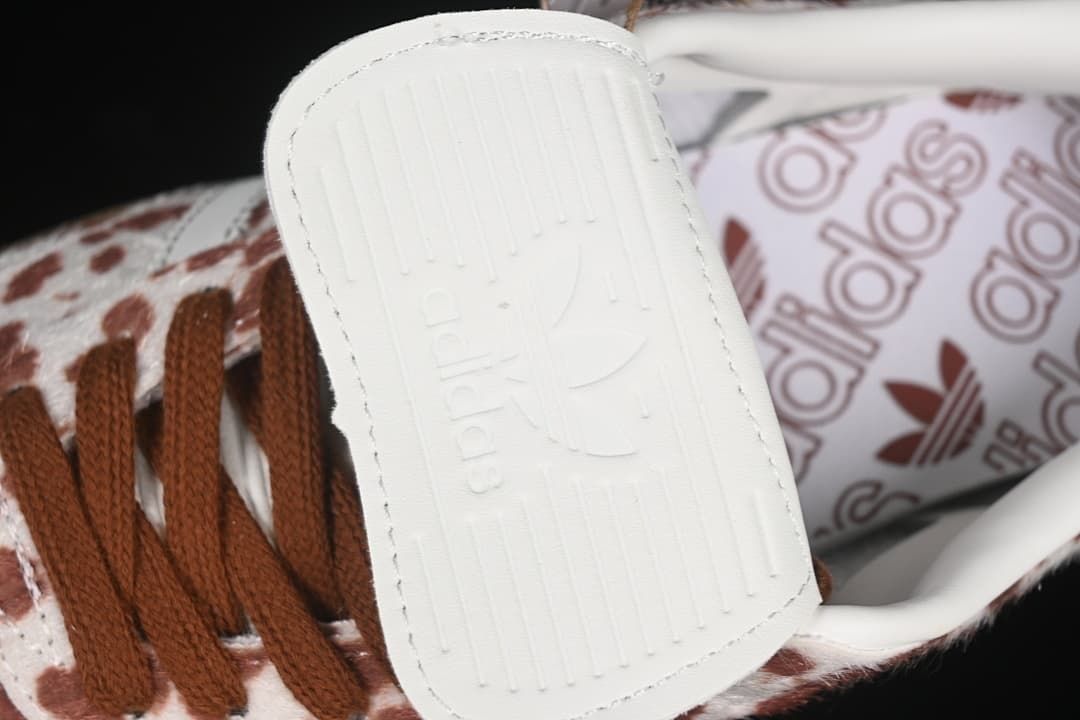 Close-up of white tongue and brown laces with patterned lining behind