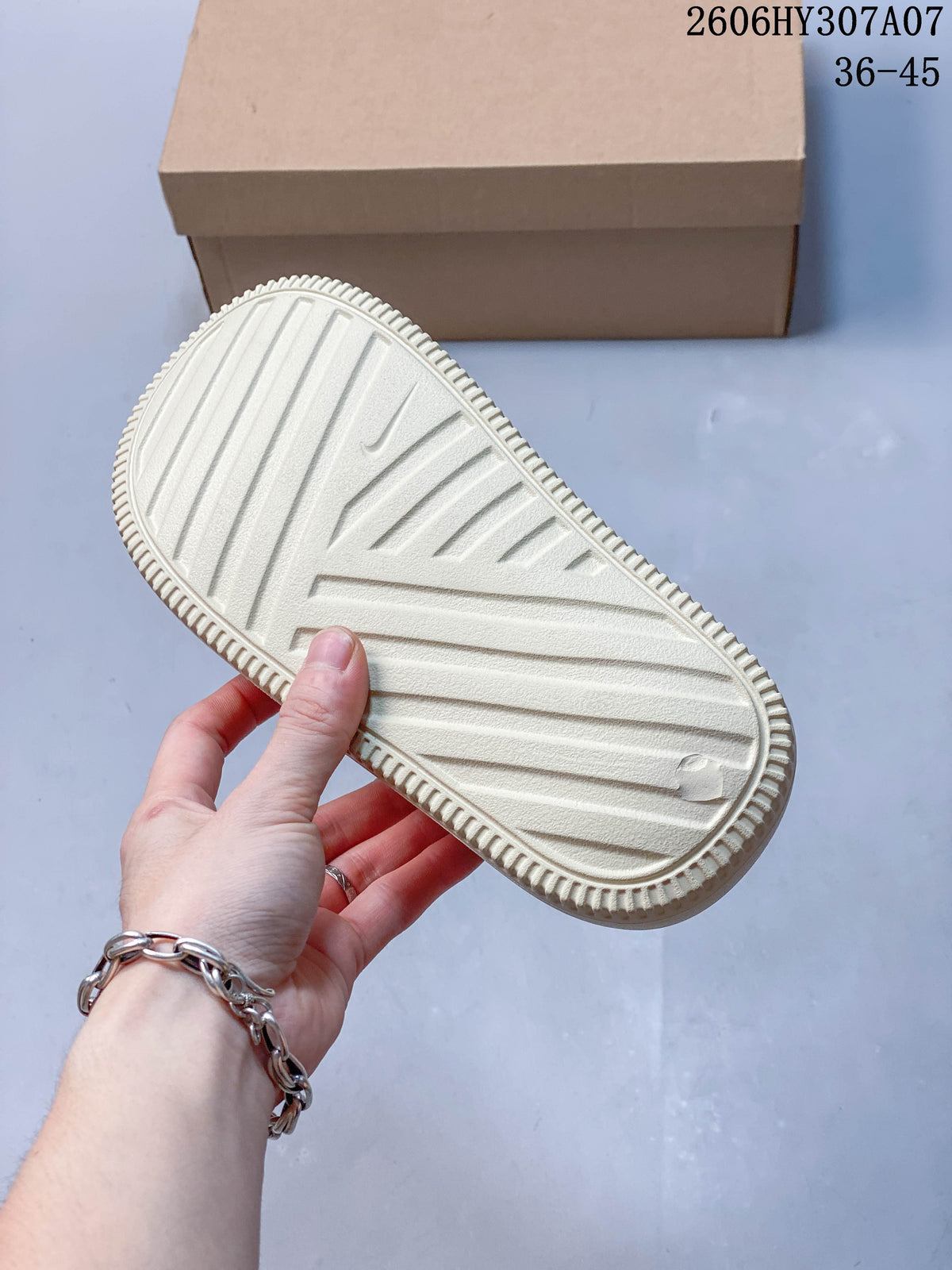 Underside of a pale cream sandal showing the ridged outsole