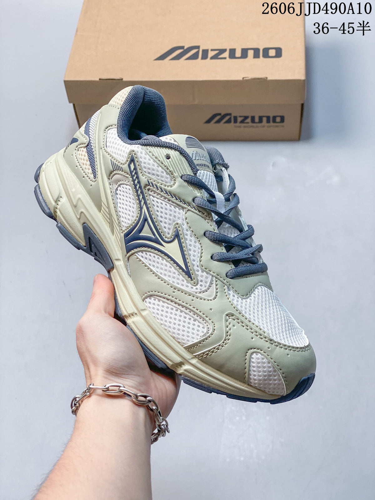 White mesh Mizuno sneaker with muted green overlays and navy laces.