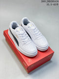 Pair of white Puma Caven 2.0 low-top sneakers with dark side stripes on a red shoe box