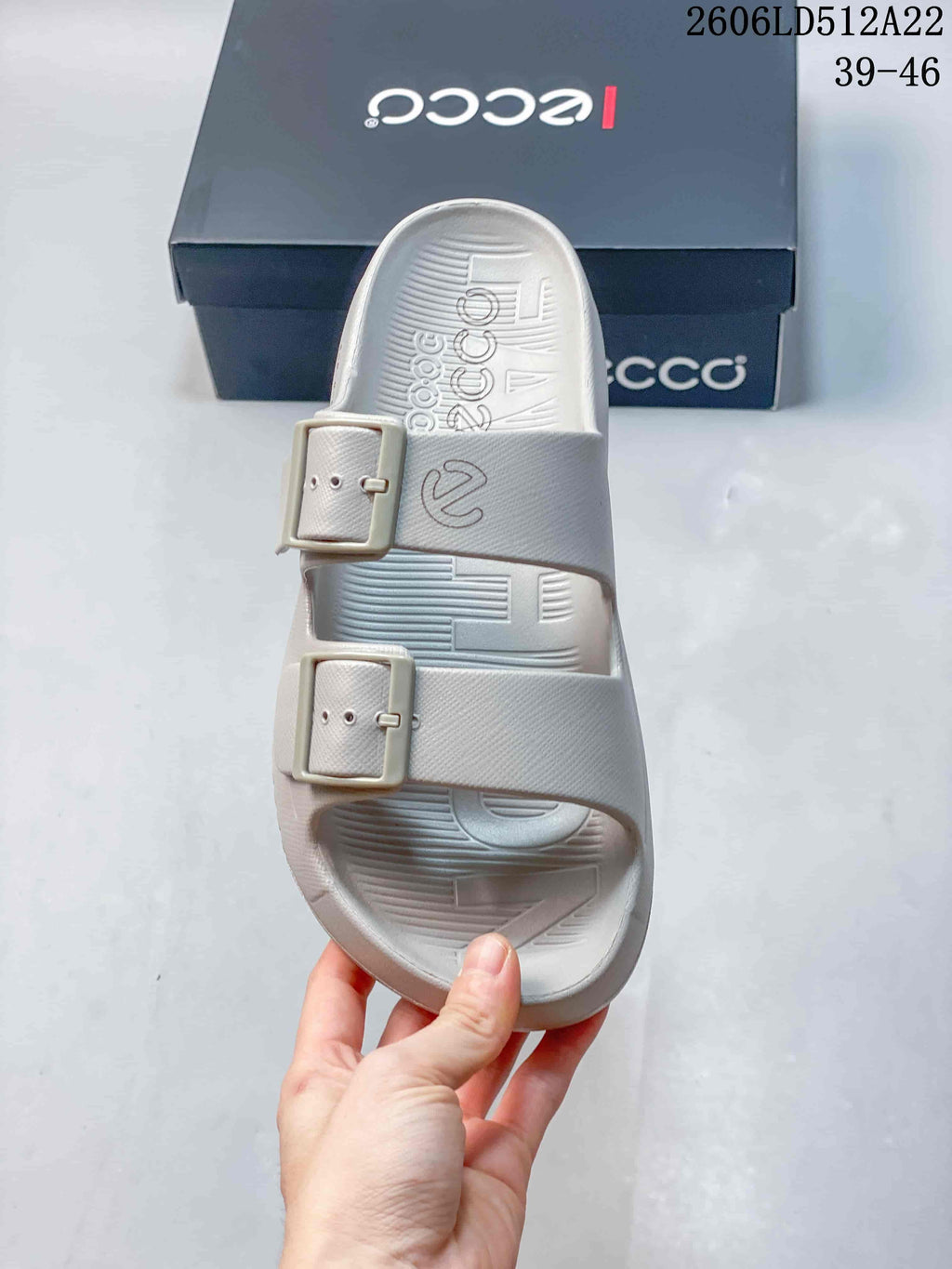 Top view of a light gray sandal showing its open toe and two buckle straps