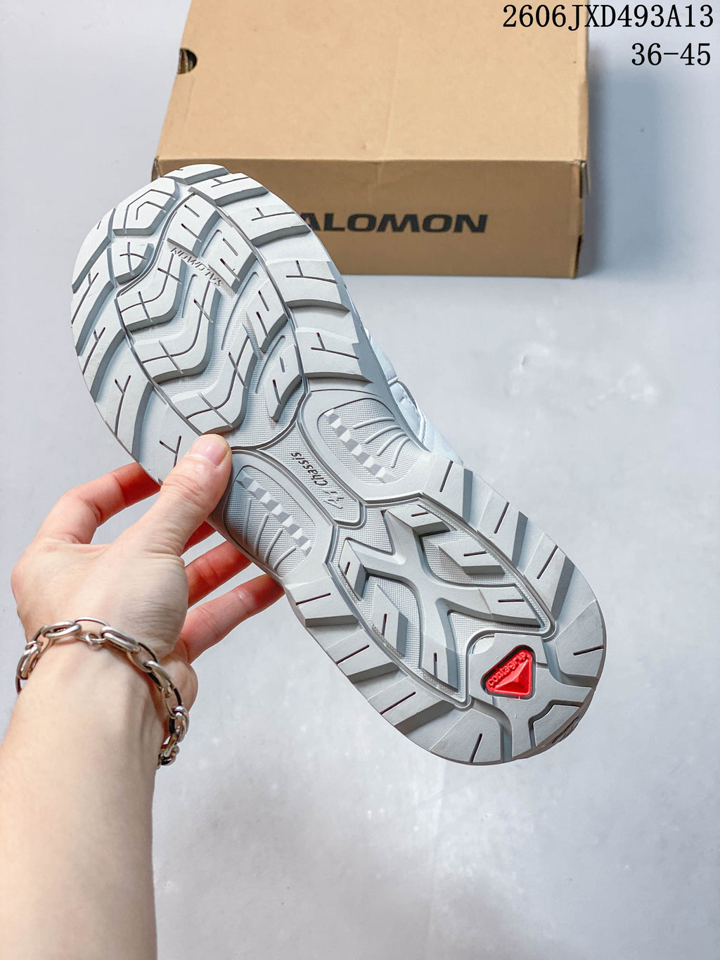 Close-up of the grey treaded outsole with a red outsole detail.