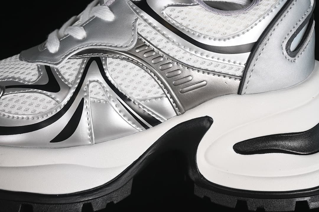 Close-up of silver and white side panels and chunky sole