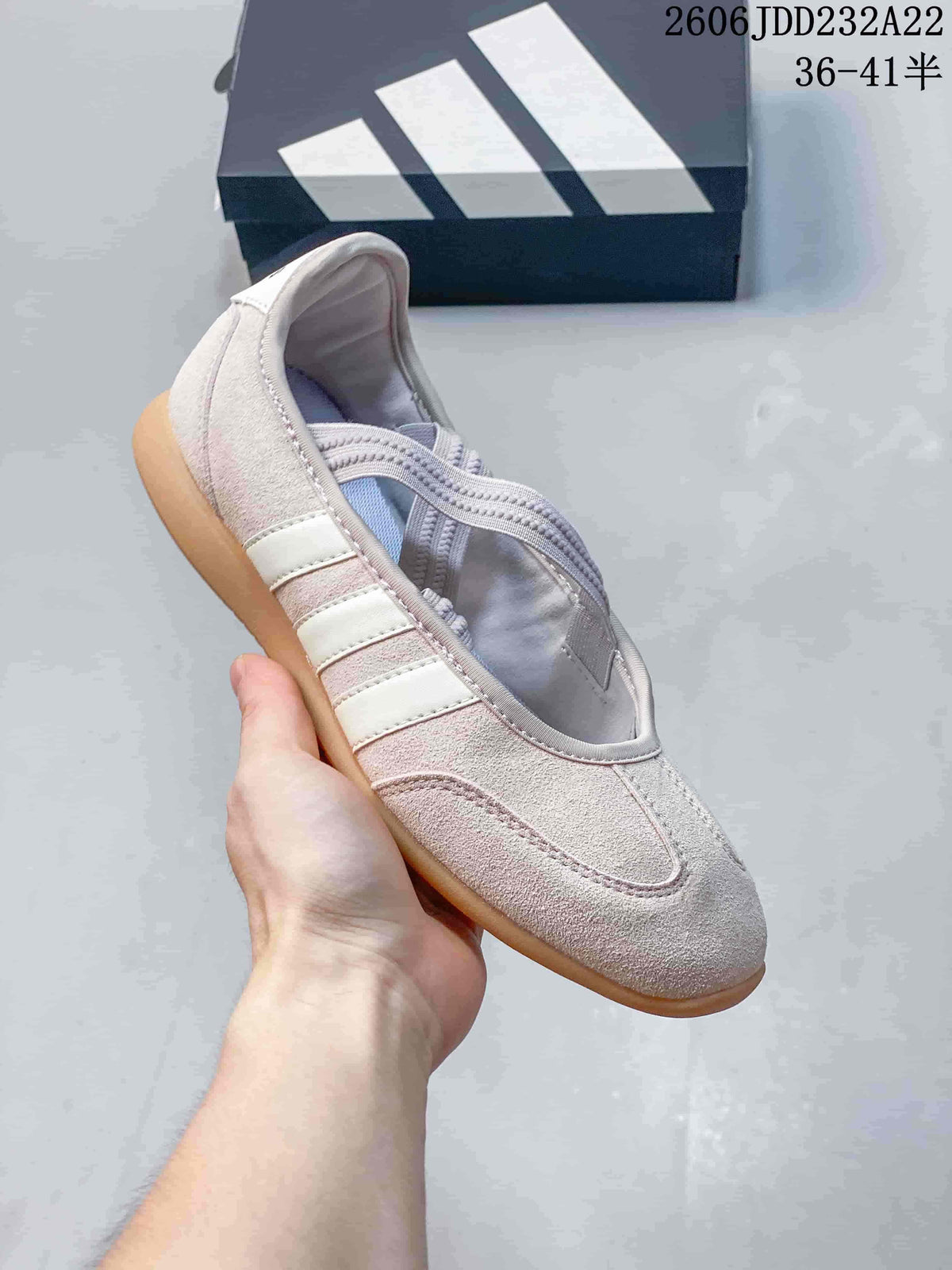 Angled close-up of the light pink shoe with crossed straps and three side stripes