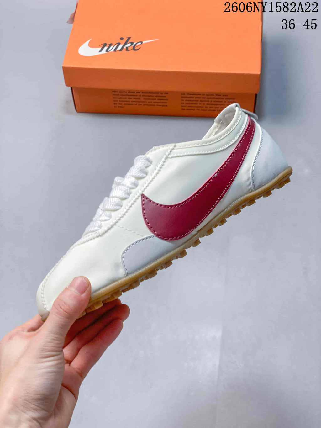 Side view highlighting the red side detail and gum-colored outsole.