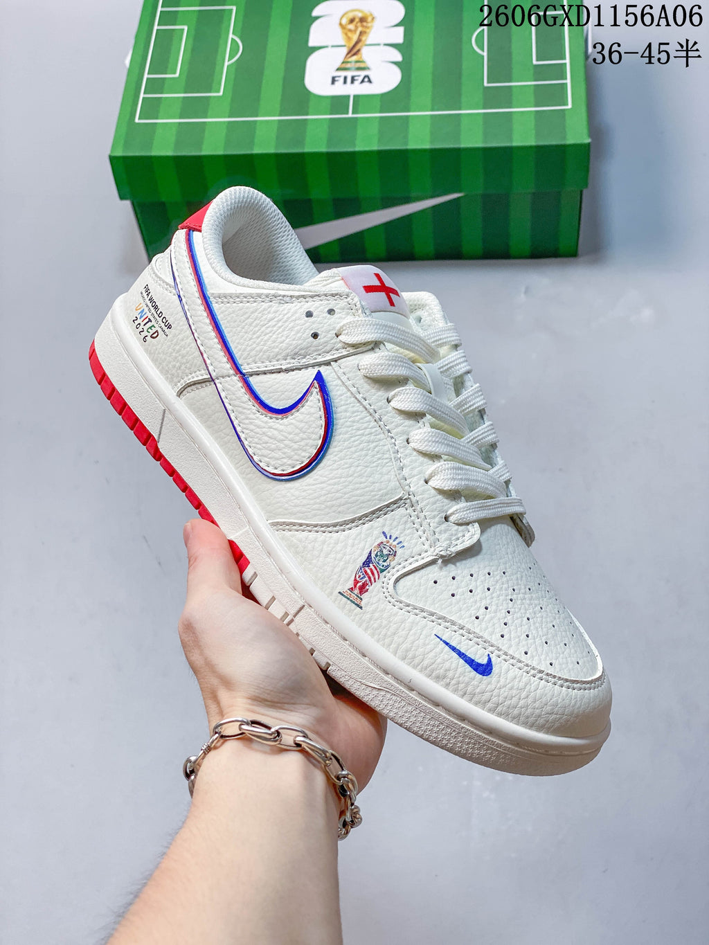 Angled side view of the sneaker showing football-themed graphics, a red-and-blue outlined Swoosh, and red outsole accents.