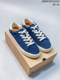 Pair of navy DESCENTE Chron Chron low-top sneakers with cream laces and light-colored soles, displayed on a DESCENTE shoe box.