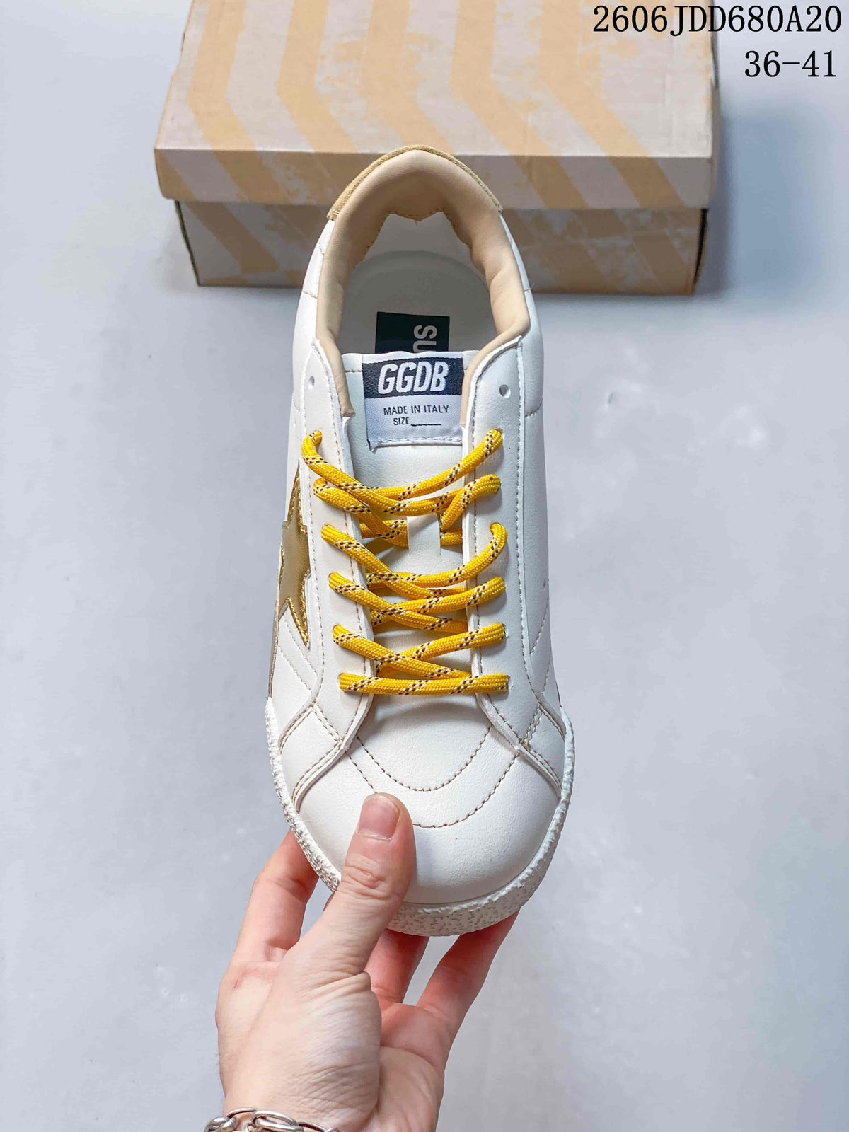 Top view of the sneaker with yellow laces and stitched panels