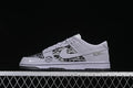 Side view of a gray and black patterned low-top sneaker with a large Swoosh-style side mark