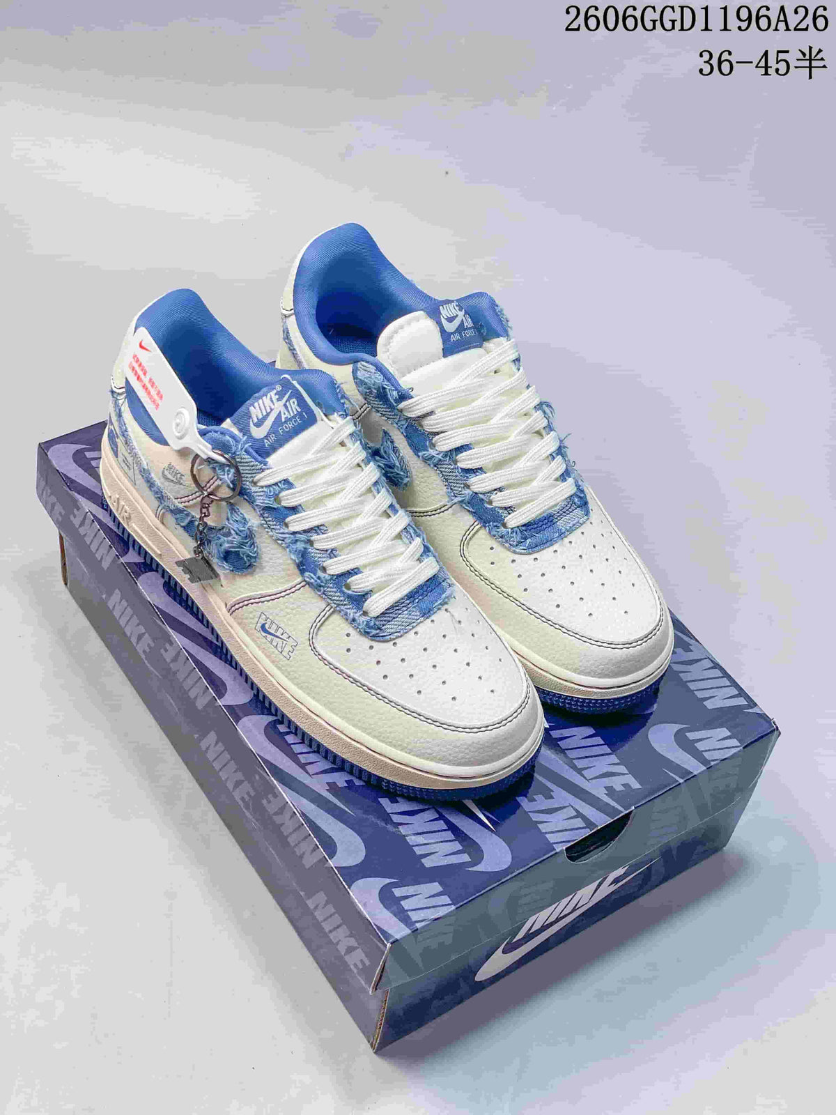 Pair of white low-top sneakers with frayed blue denim-look trim and Swooshes, displayed on a patterned box.