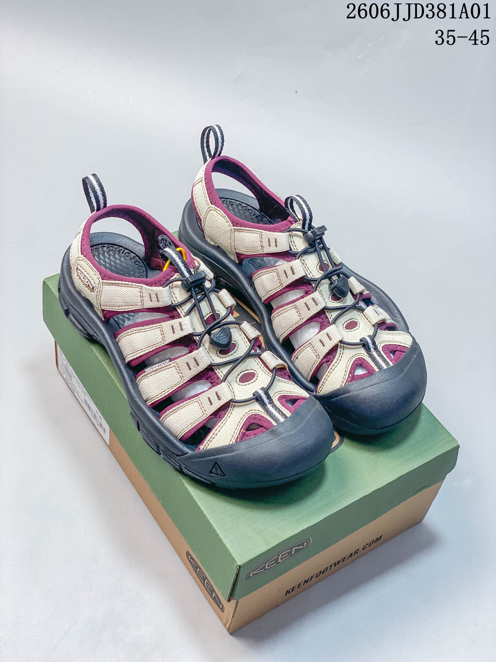 Pair of beige and plum KEEN Newport H2 sandals with dark gray soles, shown on a shoe box.