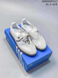 Pair of white Adidas Samba Jane sneakers with pale lavender stripes, hook-and-loop straps, and gum-tone soles on a blue shoe box