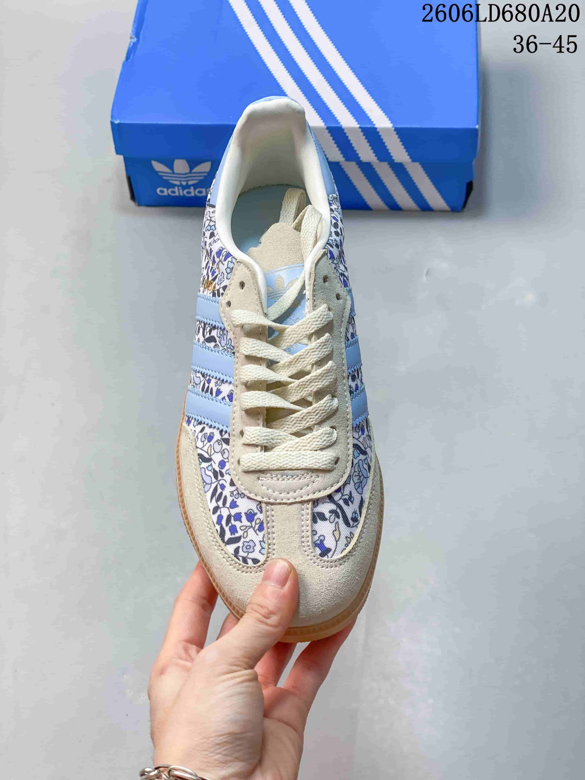 Top view of the sneaker showing cream laces and floral-print panels.