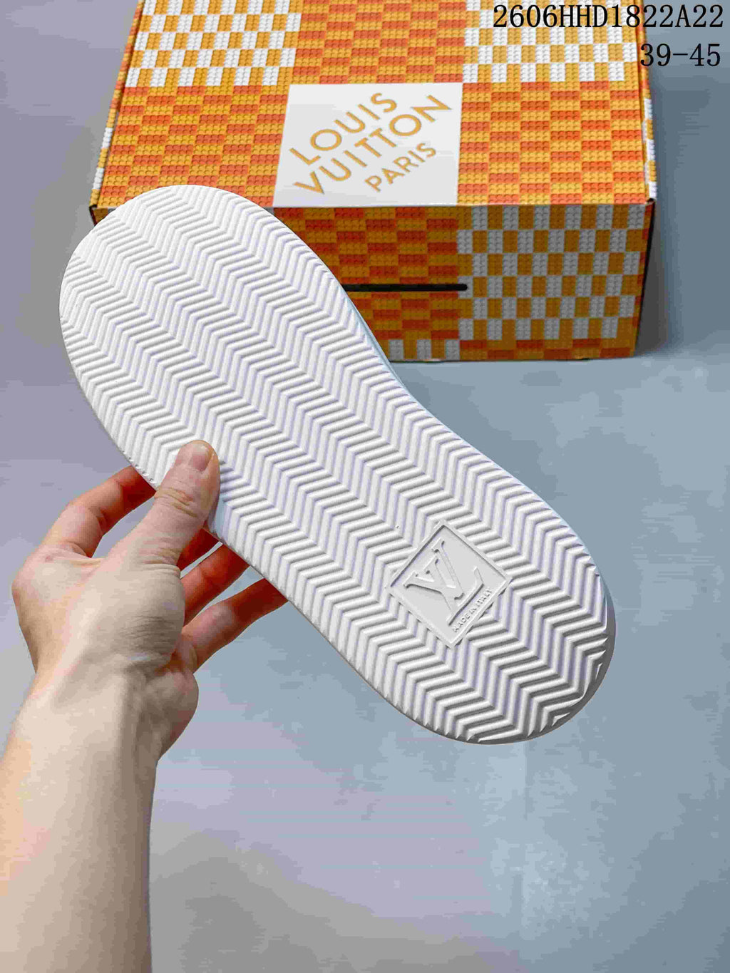 Underside of the sneaker showing a chevron-patterned tread