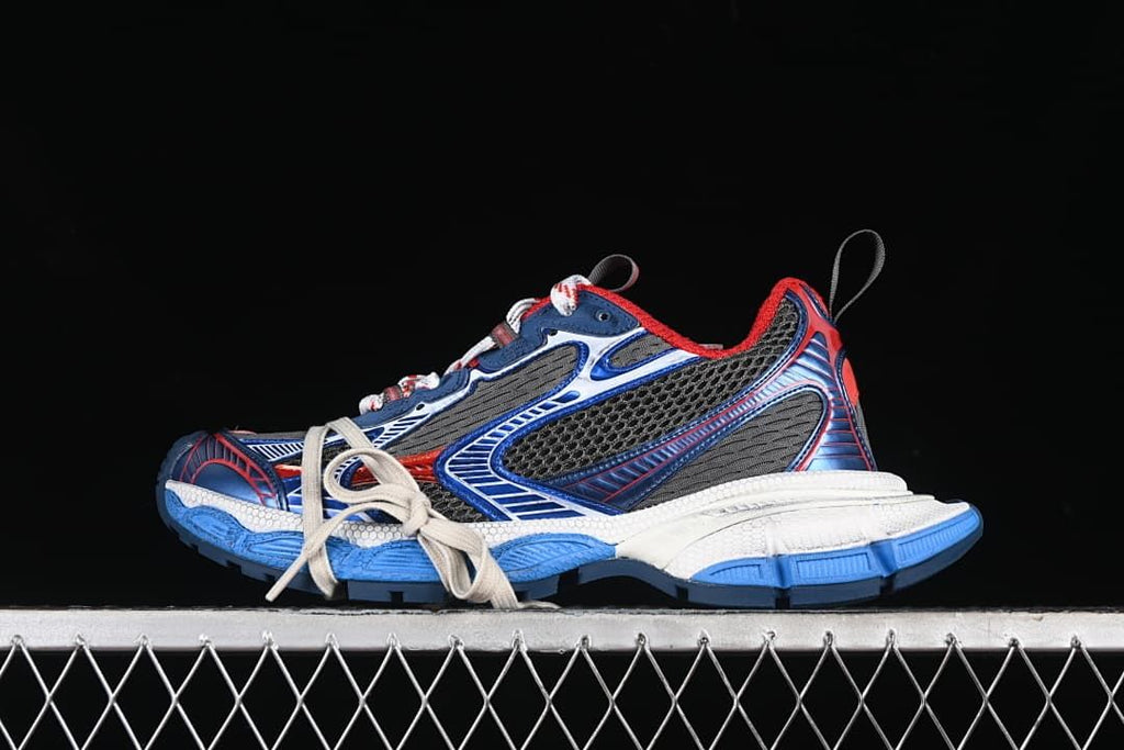 Pair of grey, blue, red and white Balenciaga Phantom sneakers against a dark background