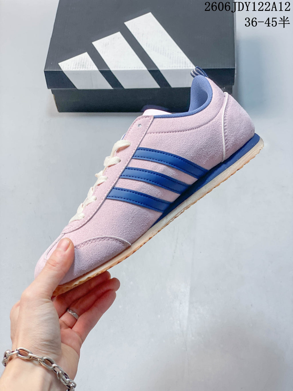 Side view of the pink low-top sneaker with blue stripes and gum-colored outsole