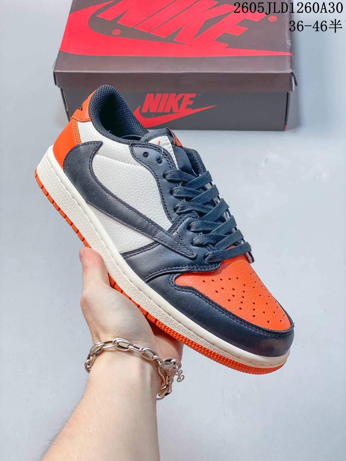 Side view of an orange, navy, and white low-top sneaker