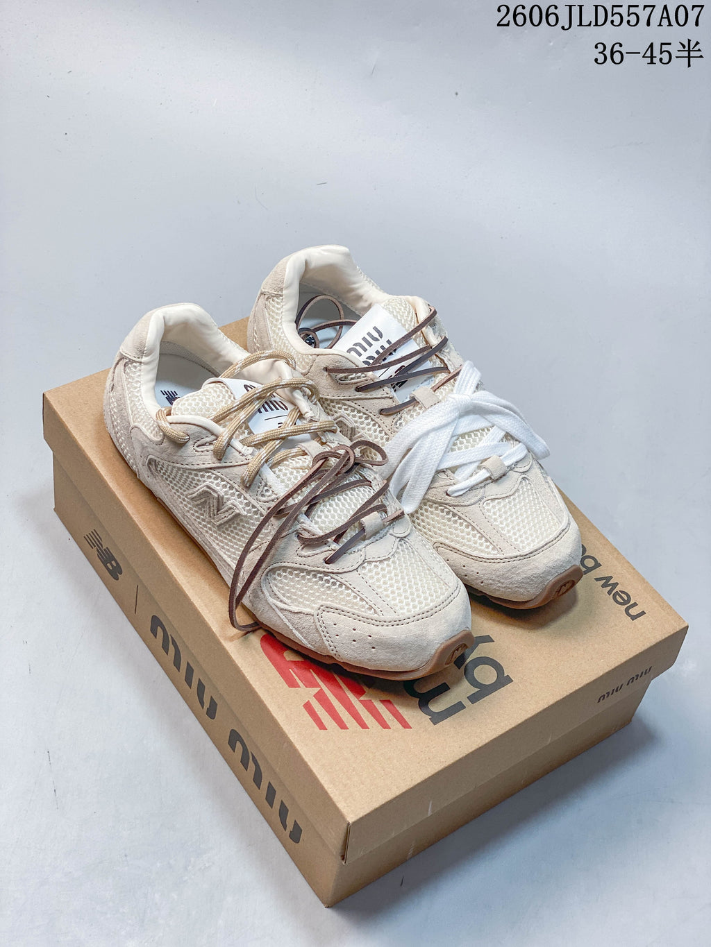 Pair of beige Miu Miu x New Balance 530 SL-style sneakers shown on a branded shoe box.