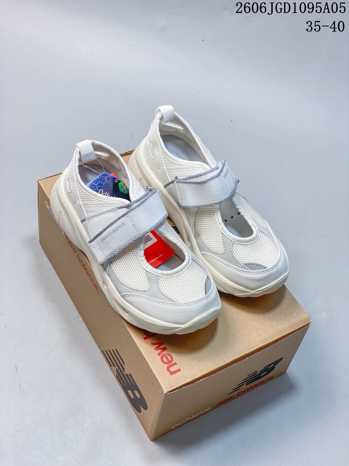 Pair of white New Balance Breeze Mary Jane sneakers with light gray straps and accents, shown on a shoebox