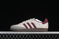 Side view of cream Adidas Samba OG sneakers with burgundy stripes, gray toe overlay, and brown outsole.