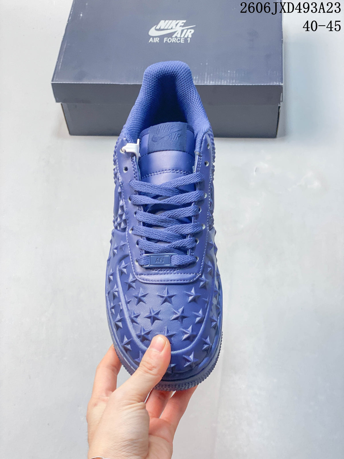 Front view of a blue Nike Air Force 1 sneaker with star-patterned toe and matching laces
